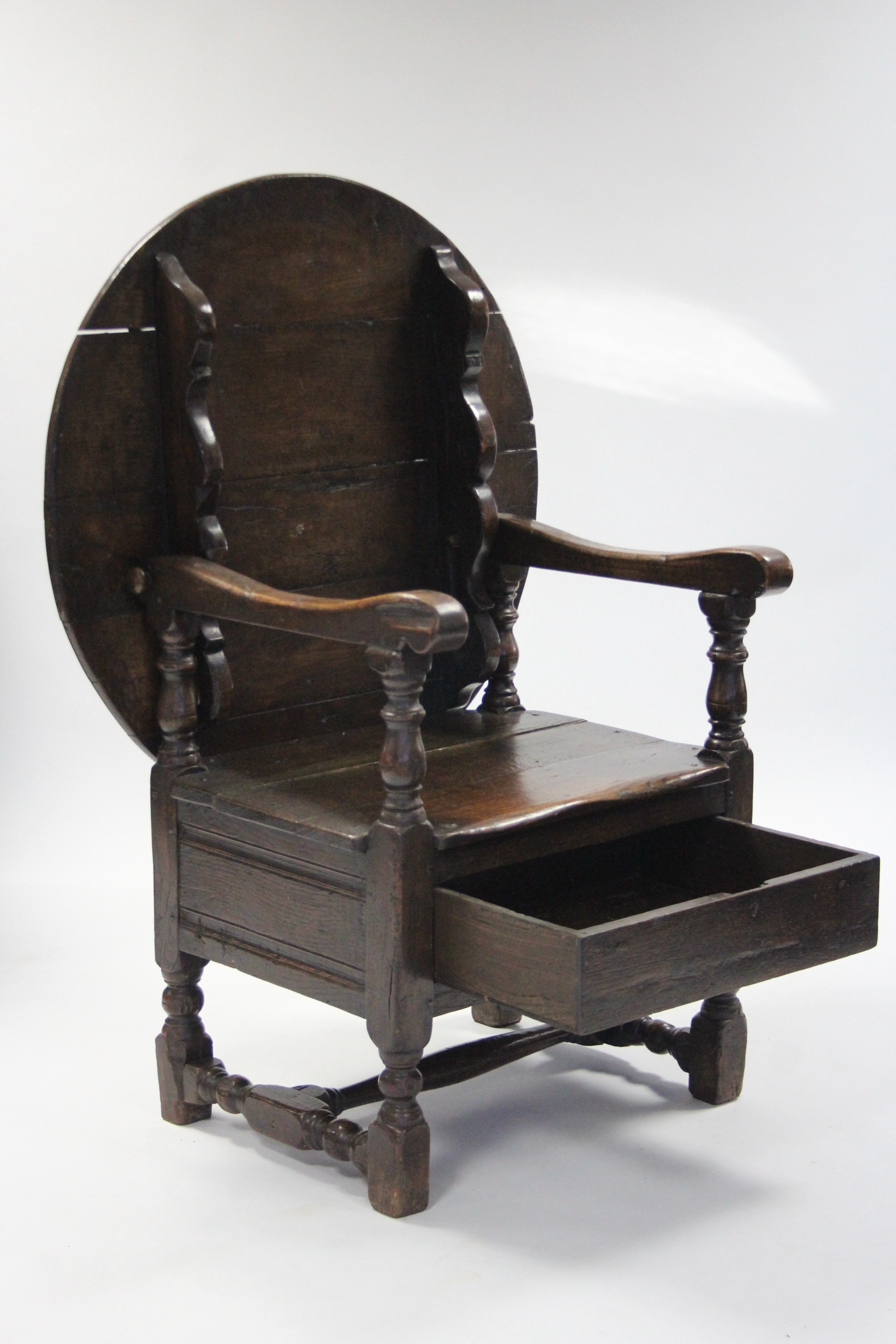 A late 17th century oak joined chairtable, the circular top tilting to form the chairback, havi