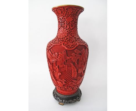 A Large Chinese red on red cinnabar carved lacquer on brass vase, decorated with scholars and attendants amongst a mountainou