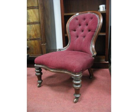 A XIX Century Mahogany Framed Parlour Chair, with spoon back, serpentine front, on turned legs, upholstered in a button back 