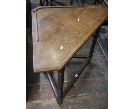 A Georgian oak corner table, the triangular top raised on four bobbin moulded suppports