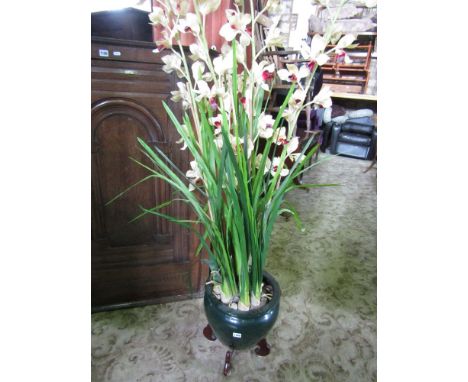 A ceramic jardiniere containing a cluster of simulated flowering orchids