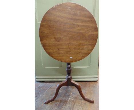 A Georgian mahogany snap top table, the single piece top 60cm in diameter raised on a slender gun barrel shaped pillar and tr