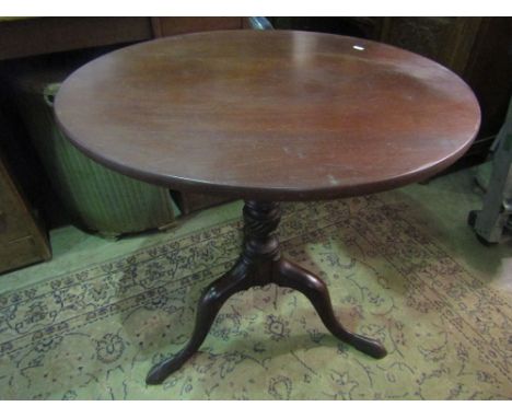 A Georgian mahogany tripod table with turned pillar and shaped tripod beneath a possibly later associated circular top