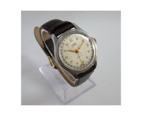 A vintage Oris automatic pointer date stainless steel mid-size wristwatch. Circular champagne dial with baton markers and Ara