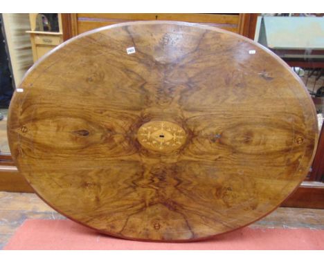 A Victorian loo table the oval walnut top with central marquetry detail raised on a bulbous column and carved tripod base  