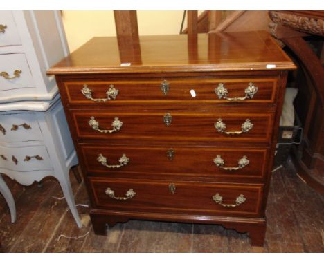 A small 19th century mahogany chest of four long graduated drawers, crossbanded in satinwood with further boxwood and ebony s