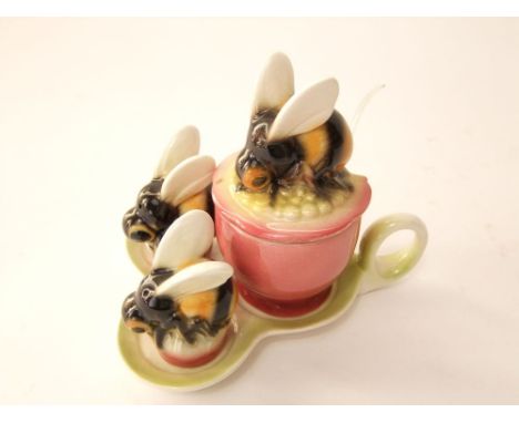 A Goebel condiment set in the form of bees on flower heads comprising mustard pot and cover, salt and pepper