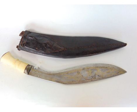 Kukri with ivory handle, the blade inlaid with yellow metal decorated with peacocks, within a dark leather scabbard