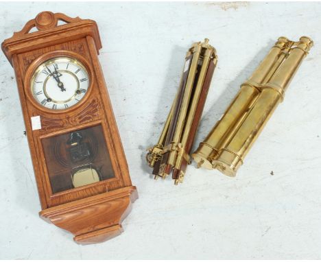 A set of modern brass binoculars on a tripod stand, together with a modern wall clock. (3)