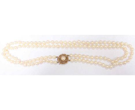 A twin strand cultured pearl necklace, the pearls of good and even colour, and set on a 9ct gold rope-twist clasp, in box.