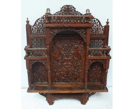 An Eastern carved hardwood wall shelf, finely carved and pierced and decorated with animals, figures and with spindle support