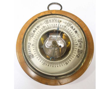 A small circular aneroid barometer, with silvered dial.