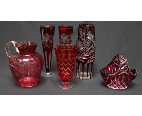 Six items of Bohemian ruby and cranberry cut glass including jugs, vases and a basket.