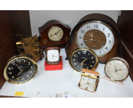 Two wooden mantel clocks together with five various alarm and travel alarm clocks and a clock movement.