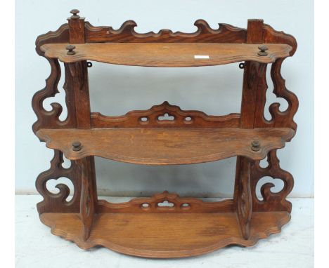 A small oak three tier wall shelf.