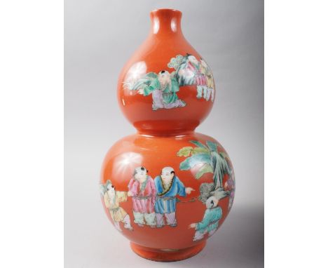 A 20th century Chinese porcelain double gourd vase, decorated children playing on a coral powder ground, seal mark to base, 1