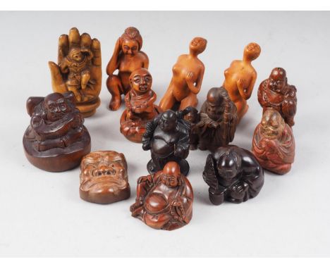 A carved hardwood netsuke, seated man with a fan, and ten other netsuke/okimono, various 