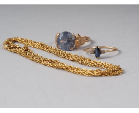 An Egyptian yellow metal ring set topaz, a yellow metal three-stone ring and a chain 