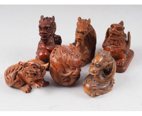 Four carved hardwood dragon netsuke and two other mythical beast netsuke 