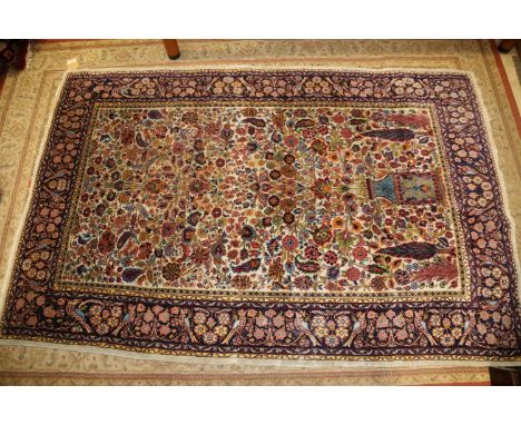 A Persian part silk pile tree and vase design rug on a light ground and multi-bordered in shades of red, blue, yellow, green 