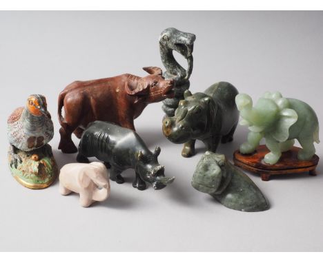 A carved jade model elephant, on hardwood stand, a hardstone hippopotamus, a similar rhinoceros and other similar items 