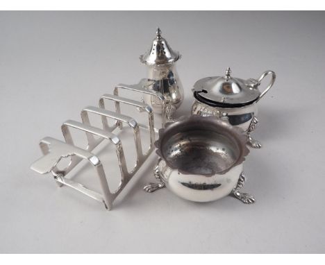 A silver mustard pot with blue glass liner, a matching pepper pot and salt, and a Mappin &amp; Webb Art Deco style toast rack