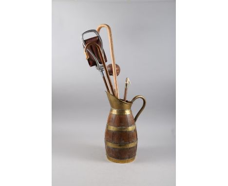 A brass coopered oak jug/stick stand, a number of walking sticks and a shillelagh 