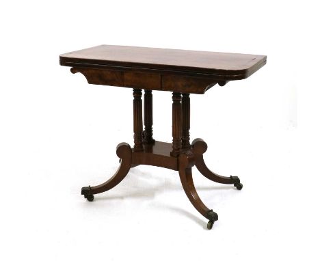 A George IV mahogany card table,c.1825, the rounded rectangular top with strung detail, enclosing a red baize-lined playing s