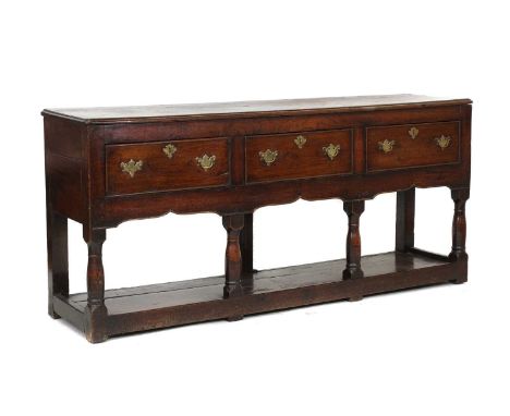 An oak dresser base,18th century, with three drawers, a shaped apron and a pot board,175.5cm wide40.5cm deep79cm highIt does 
