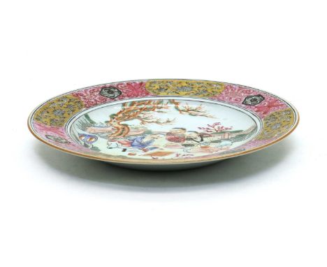 A Chinese famille rose plate,the shallow rounded sides rising from a circular foot, painted with three literati playing go in