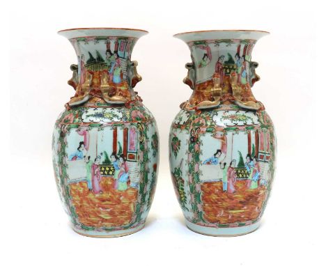 A pair of Chinese Canton famille rose vases,late 19th century, of baluster form with a flared mouth, applied with Buddhist li