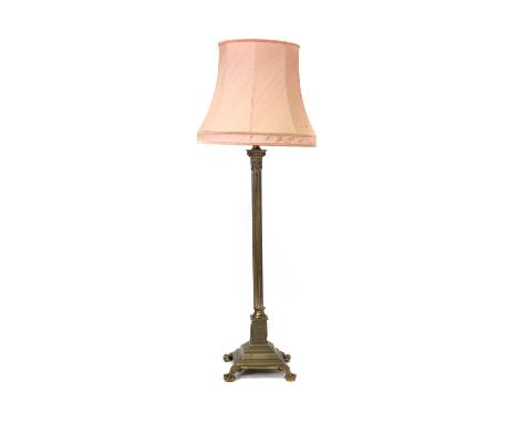 A brass Corinthian column standard lamp,raised on claw and ball feet, with a pink shade,overall 170cm highShade damaged and w