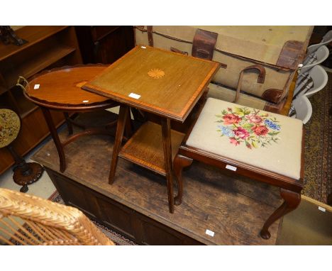 An Edwardian mahogany inlaid two-tier side table; an Edwardian tray-top table with brass handles and mahogany stool with flor