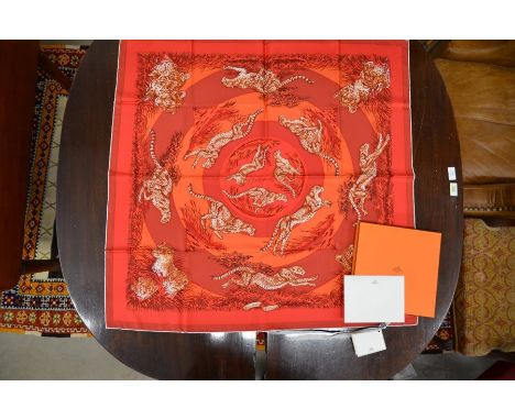 An Hermes silk, Carretwill scarf 'Guepards', printed with cheetah on a red and coral ground, boxed as new complete with 2014 