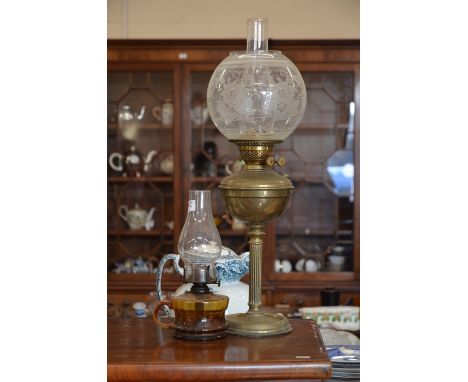 A brass oil lamp with floral etched shade to/w a small smoked glass oil lamp (2)