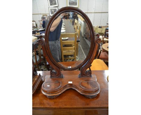 A large Victorian mahogany framed oval dressing table mirror with high scrolling supports and shaped platform base incorporat