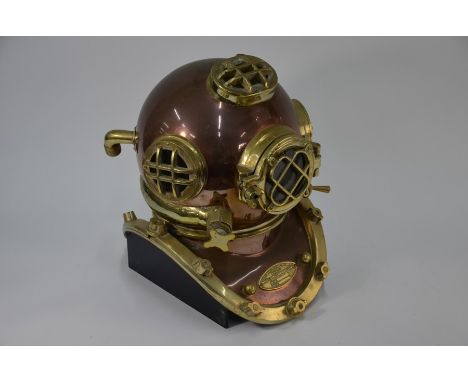 A reproduction brass and copper US Navy divers helmet, on wooden display stand, 44 cm h o/allPlease note that all lots are se