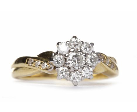 EIGHTEEN CARAT GOLD DIAMOND CLUSTER RINGthe diamond daisy cluster bezel set with round brilliant cut stones, on crossover dia
