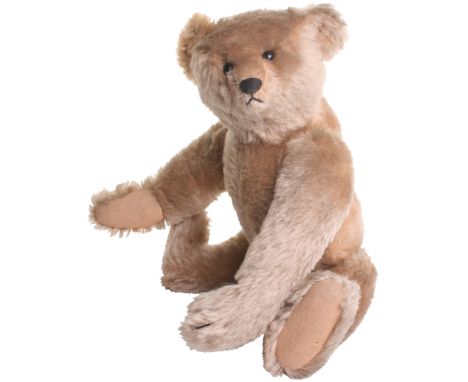 A Fine Steiff Teddy bear German, circa 1909, the straw filled light brown mohair bear with black boot button eyes, stitched n