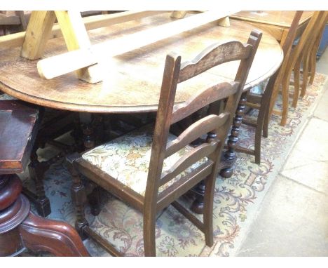 AN OAK DROP LEAF TABLE AND 4 LADDER BACK CHAIRS. 