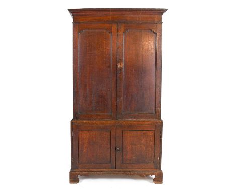 ~  A George III Oak Cupboard, late 18th century, the moulded cornice above a plain frieze and moulded cupboard doors enclosin