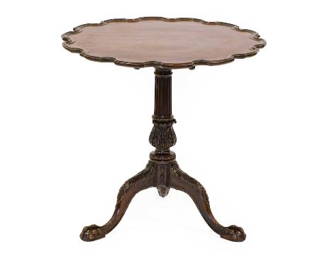 A Carved Mahogany Pie-Crust Tripod Table, in George II style, the moulded top above a fluted and acanthus carved support with