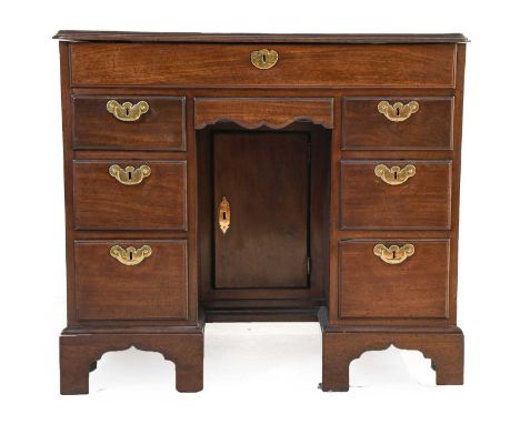 ^ A George III Mahogany Kneehole Writing Desk, circa 1770, the moulded and crossbanded hinged lid enclosing a fitted interior