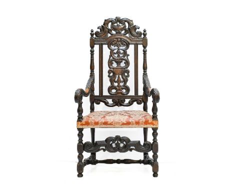 ~  A 17th Century Carved Walnut Open Armchair, recovered in dark-pink floral fabric, the scrolled and pierced top rail above 