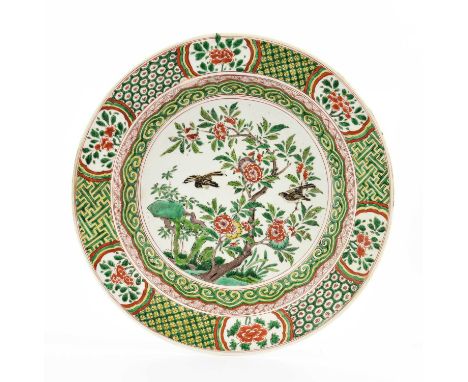 A Chinese Porcelain Basin, Kangxi, painted in famille verte enamels with birds amongst flowering peony and rockwork within cl