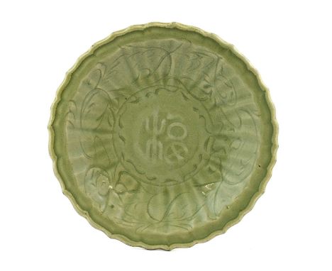 A Chinese Longquan Celadon Glazed Dish, 15th/16th century, carved with calligraphy within a fluted border incised with stylis