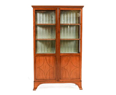 ~  A Victorian Satinwood Bookcase, late 19th century, the moulded top above glazed and panelled doors with ebony and tulipwoo