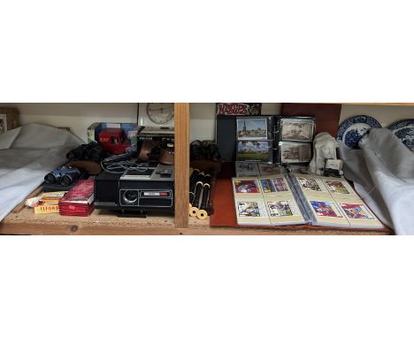 Two albums of Royal Mail postcards together with other postcards, projector, binoculars, Junghans Ato-mat clock, Postman Pat 