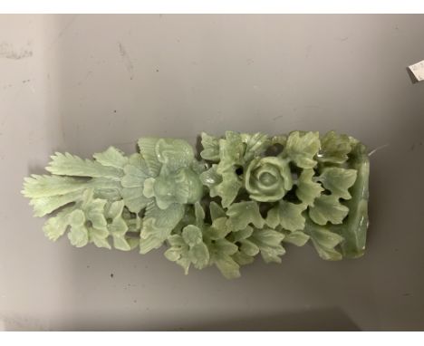 A large piece of pale green jade carved with an Oriental scene depicting flowers and trees. In presentation box. W:15cm x D:4