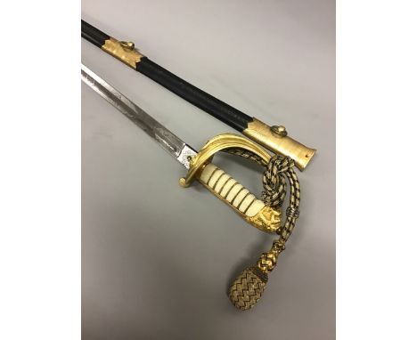 An early 20th century naval dress sword with gilt basket and shagreen grip with inscription for WJ Whitaker RN. Etched blade 